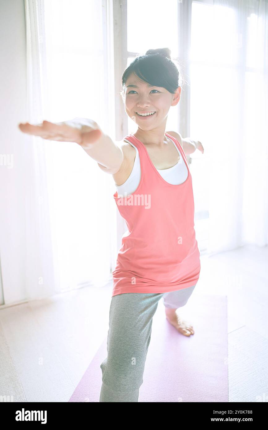 Donna che pratica yoga alla finestra Foto Stock