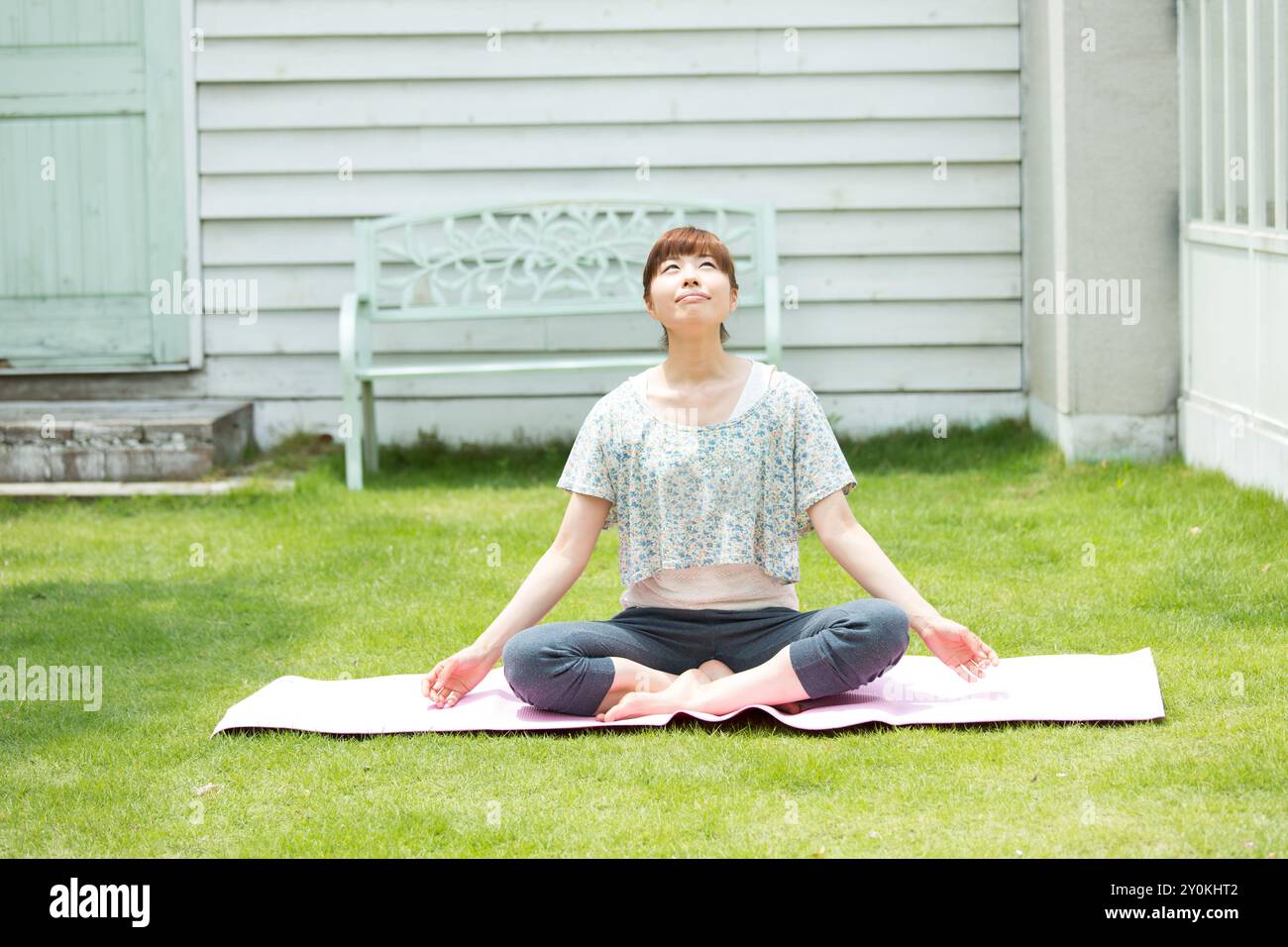 Donna che ama lo yoga sul prato Foto Stock
