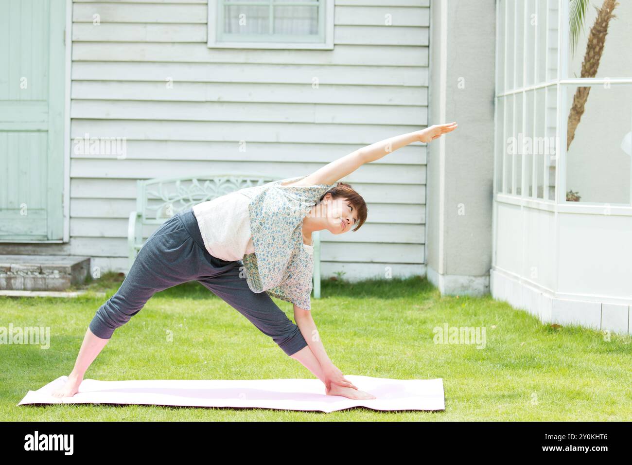 Donna che ama lo yoga sul prato Foto Stock
