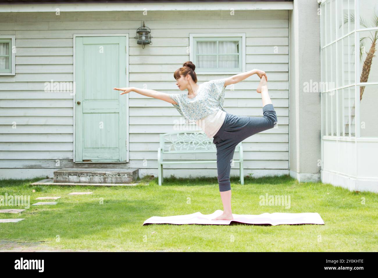 Donna che ama lo yoga sul prato Foto Stock