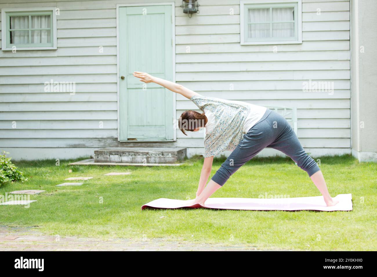 Donna che ama lo yoga sul prato Foto Stock