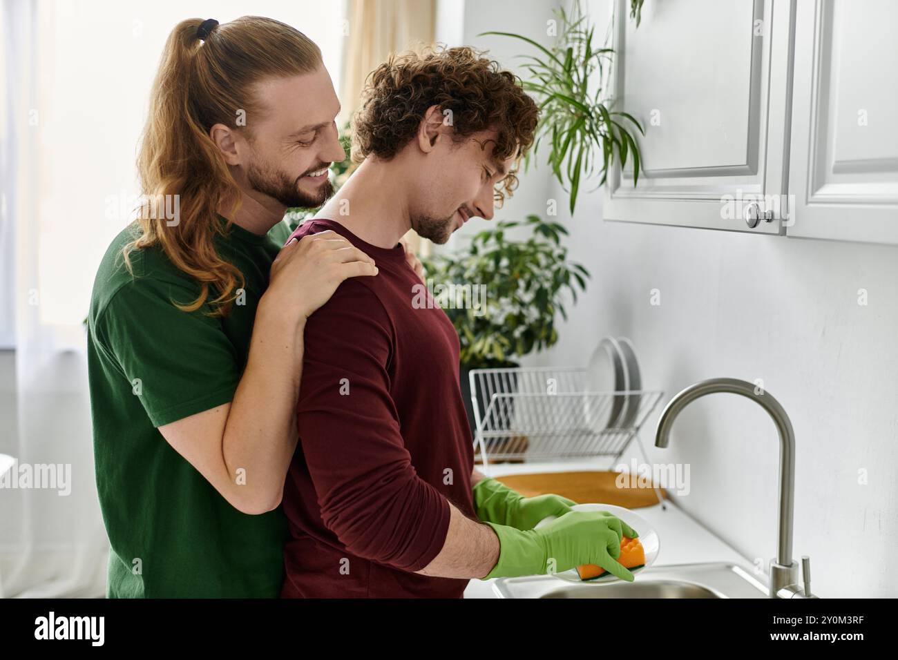 Due partner condividono un momento di gara durante la preparazione di un pasto. Foto Stock