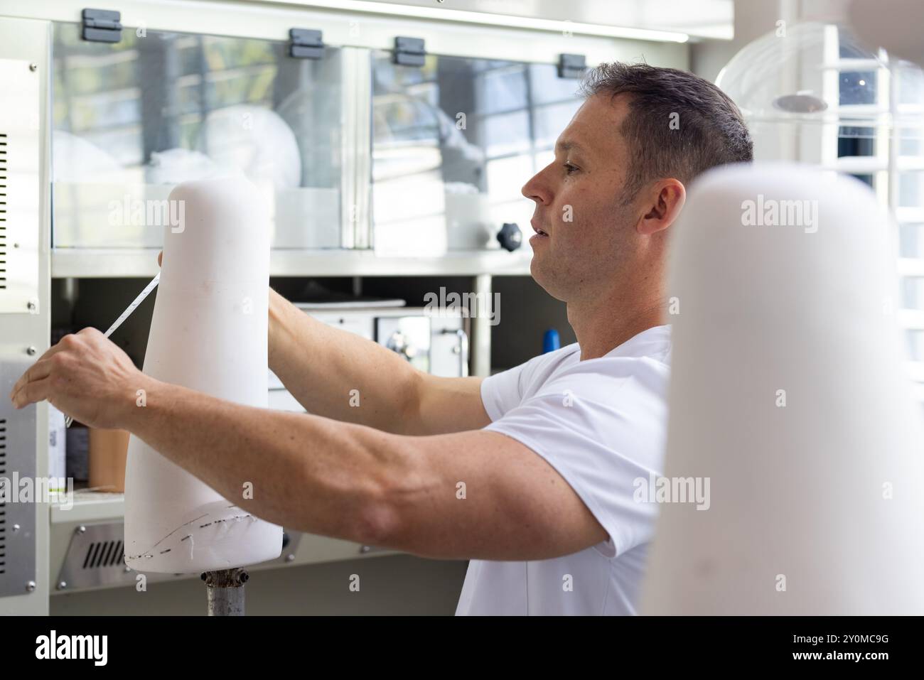 Misurazione della protesi dell'arto, tecnico che lavora in laboratorio, concentrandosi sulla precisione Foto Stock