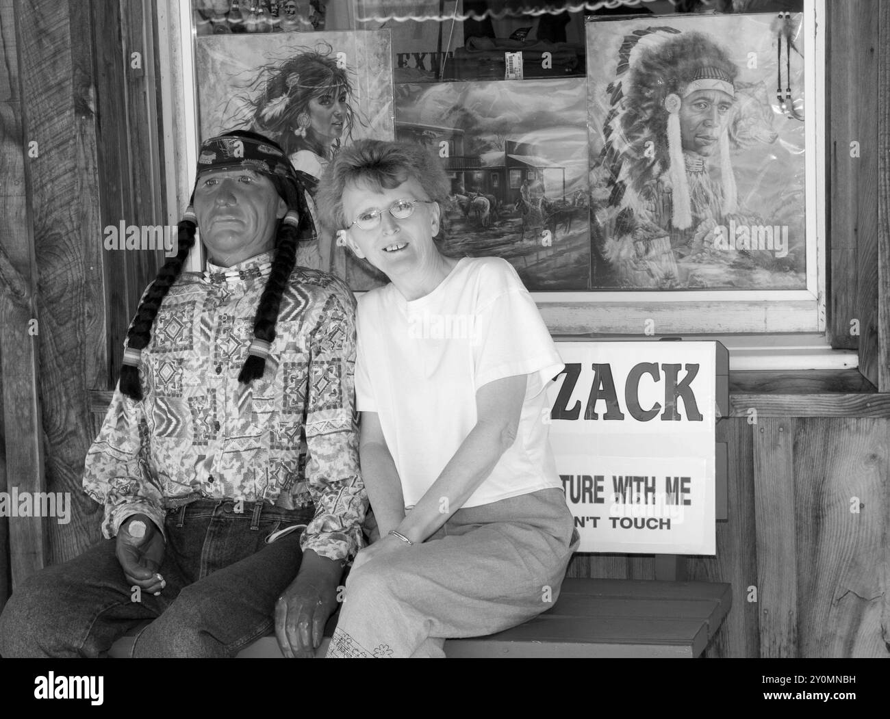 Una turista caucasica, di età compresa tra i 55 e i 60 anni, seduta accanto ad una mostra indiana al Wall Drug Store, South Dakota, USA. Foto Stock
