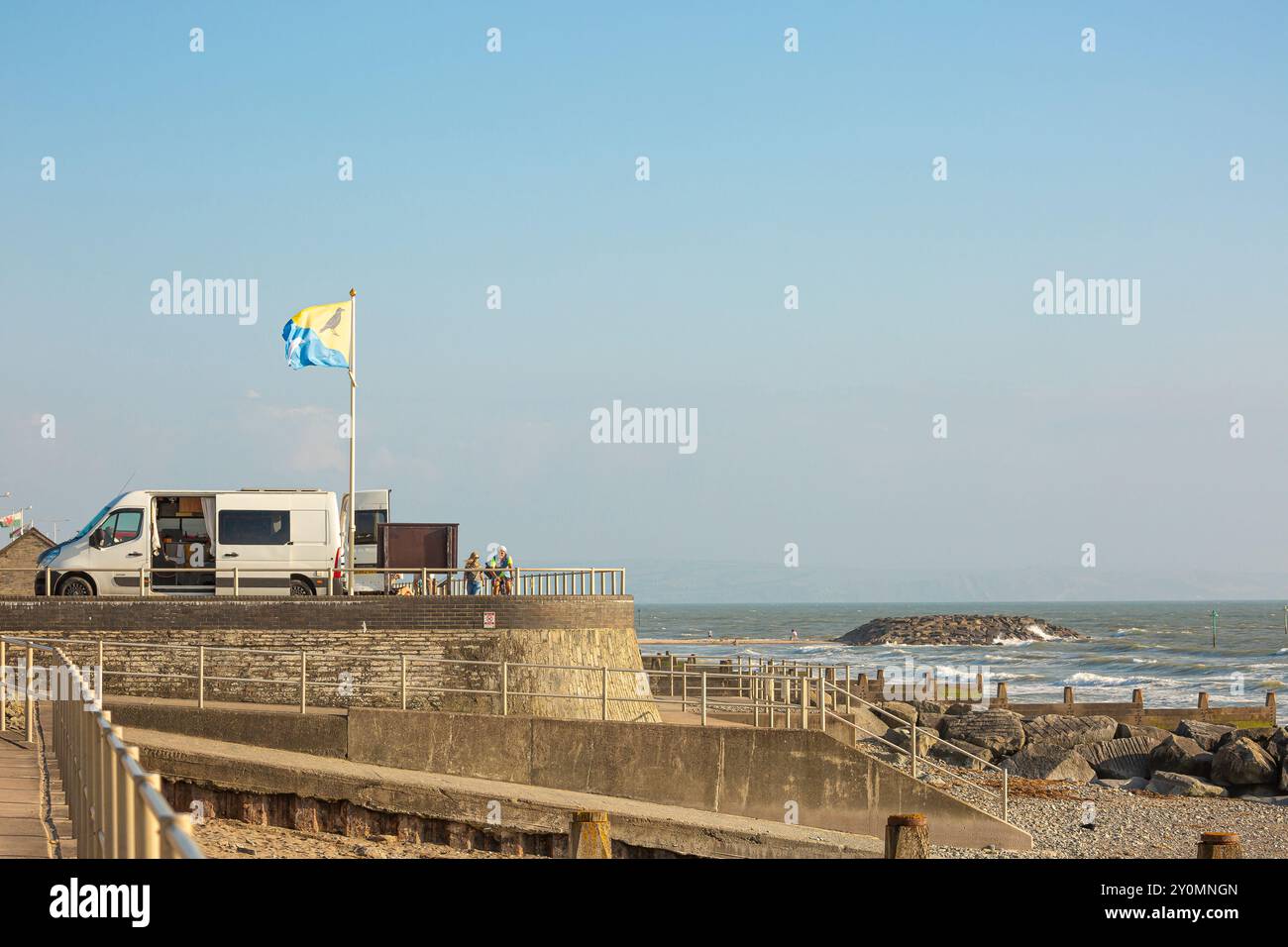 Camper parcheggiato in una spiaggia costiera di ghiaia a Tywyn Beach, Gwynedd, Galles del Nord, Regno Unito Foto Stock