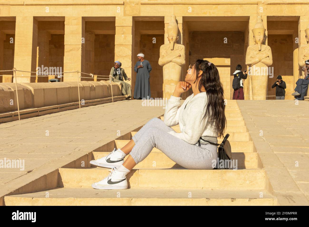 Luxor, Egitto; 16 gennaio 2024: Donna che visita il tempio funerario di Hatshepsut nell'antica capitale egiziana di Tebe. Terra di faraoni e miste Foto Stock