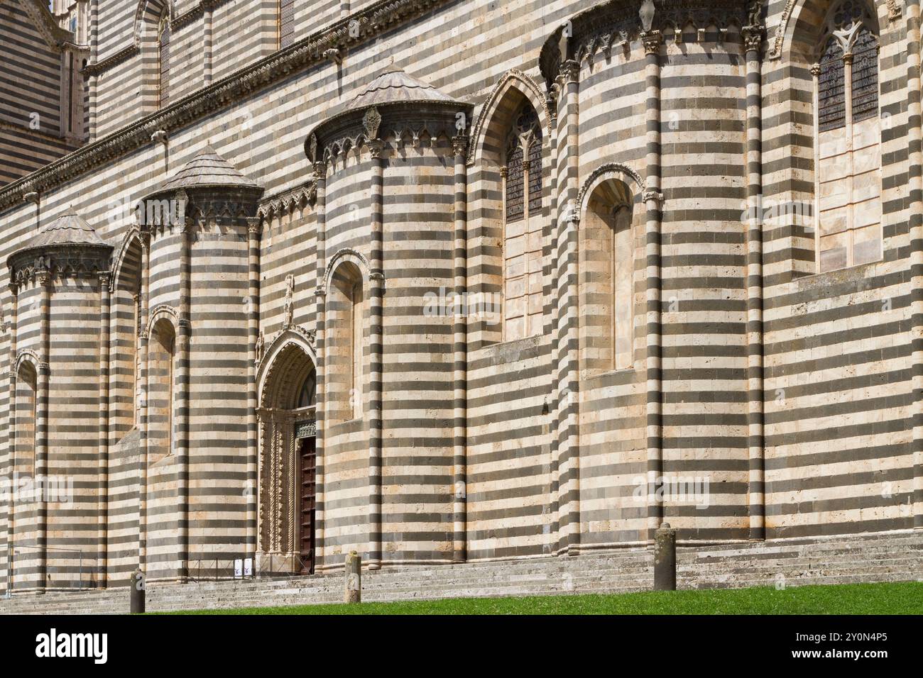 Pareti laterali del Duomo di Orvieto con strati alternati di pietra bianca e nera Foto Stock