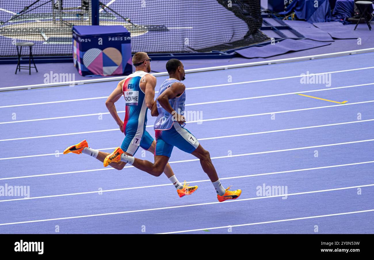 L'atleta paralimpico francese cieco Timothée Adolphe con la sua guida che corre per i 400 m nello Stade de France per i Giochi paralimpici di Parigi 2024. Foto Stock