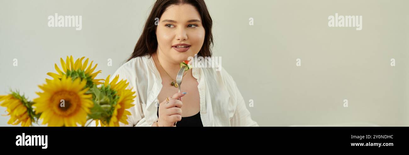 Una donna gioiosa si vizierà con un delizioso pasto circondato da vibranti girasoli. Foto Stock