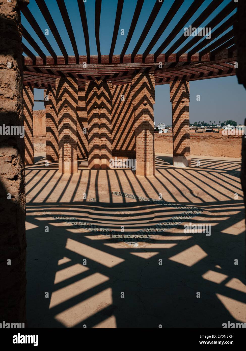 L'interazione tra luce solare e ombre crea accattivanti motivi geometrici all'interno di una struttura desertica, evidenziando un design architettonico e un'atmosfera unica Foto Stock
