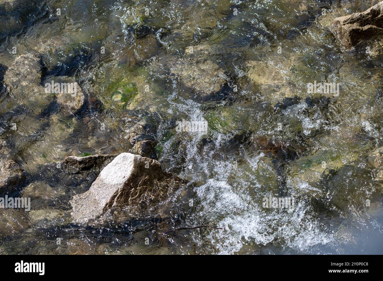 , Deutschland, 03.09.2024, Nahaufnahme eines Flussbettes, in dem klares Wasser über Steine fließt. Die Bewegung des Wassers erzeugt kleine Wellen und Foto Stock