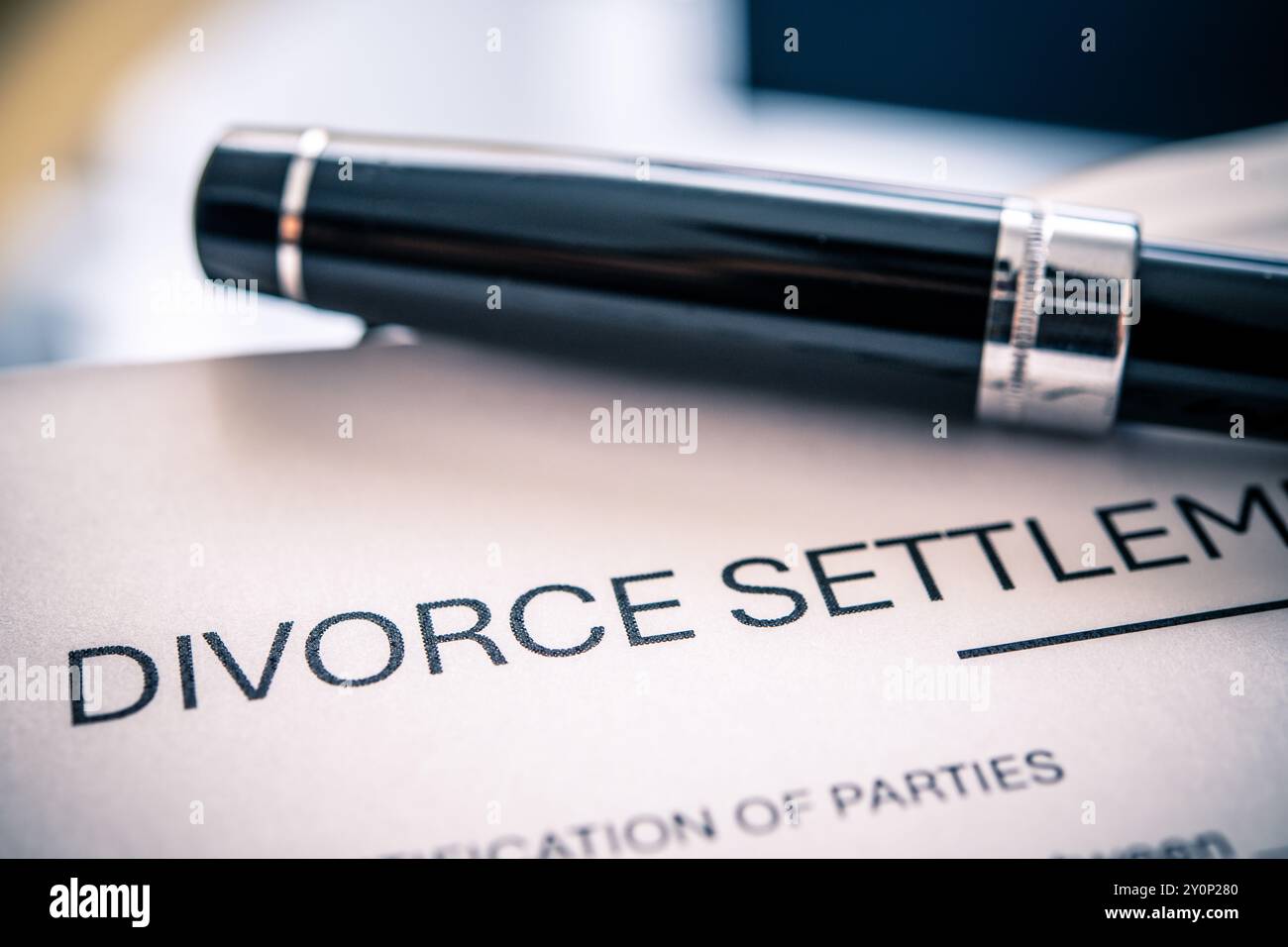 Un accordo di divorzio messo in evidenza con un'elegante penna nera che serve come strumento per firmare documenti legali relativi alla separazione coniugale Foto Stock