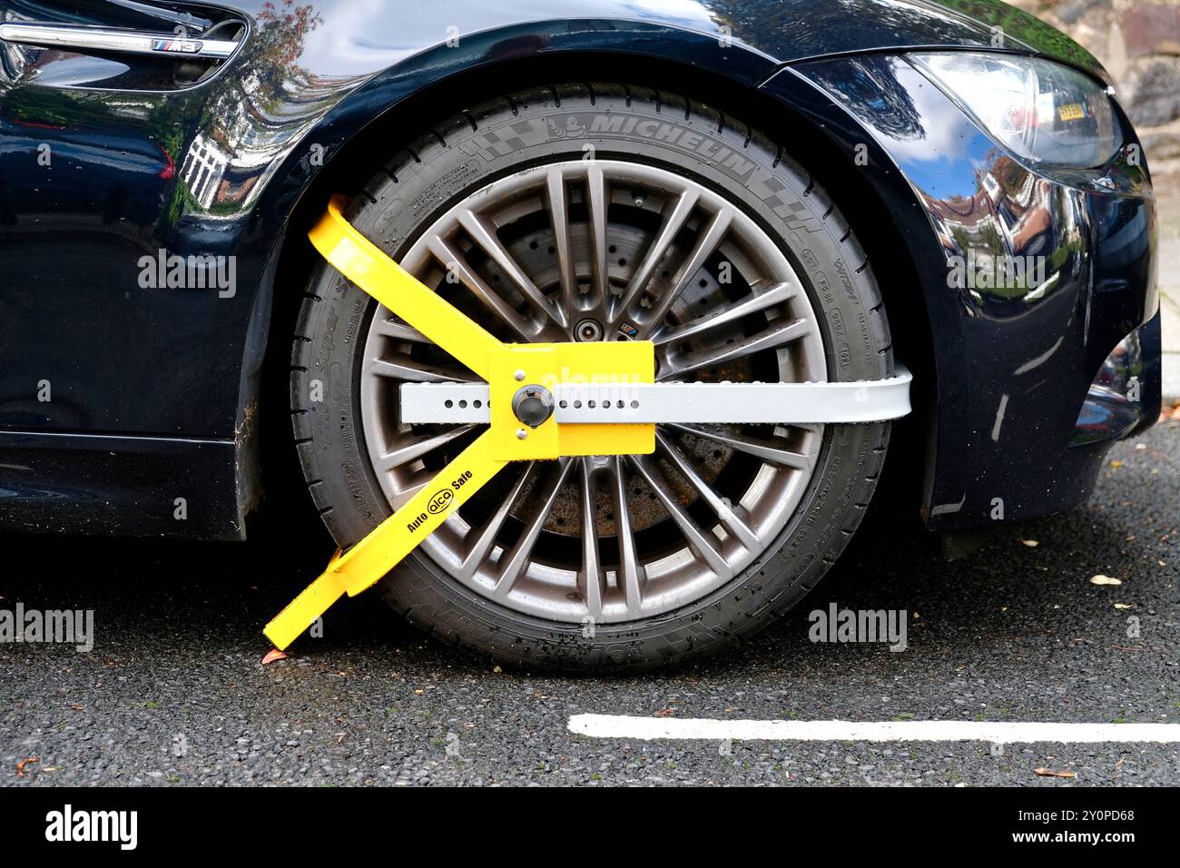 Un morsetto per ruota antifurto montato su un'auto parcheggiata in una strada di periferia a nord di Londra. Foto Stock