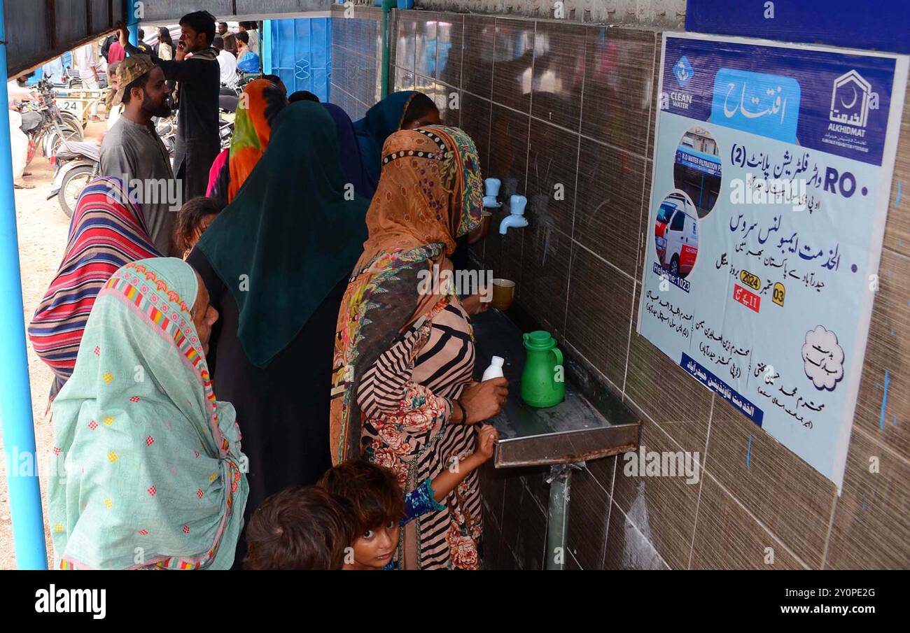 Le persone stanno bevendo acqua e riempiono le loro bottiglie d'acqua dall'impianto filtrante dopo la cerimonia di inaugurazione R.. O impianto di filtrazione dell'acqua organizzato dalla al- Khidmat Foundation, tenuto presso la sede dell'ospedale civile di Hyderabad martedì 3 settembre 2024. Foto Stock