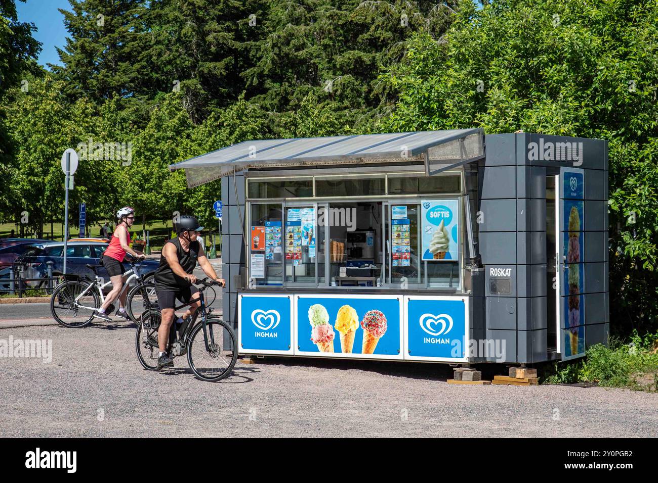 Uomo in bicicletta che controlla l'offerta del chiosco gelati Ingman di Merisatamanranta in una soleggiata giornata estiva nel quartiere Ullanlinna di Helsinki, Finlandia Foto Stock