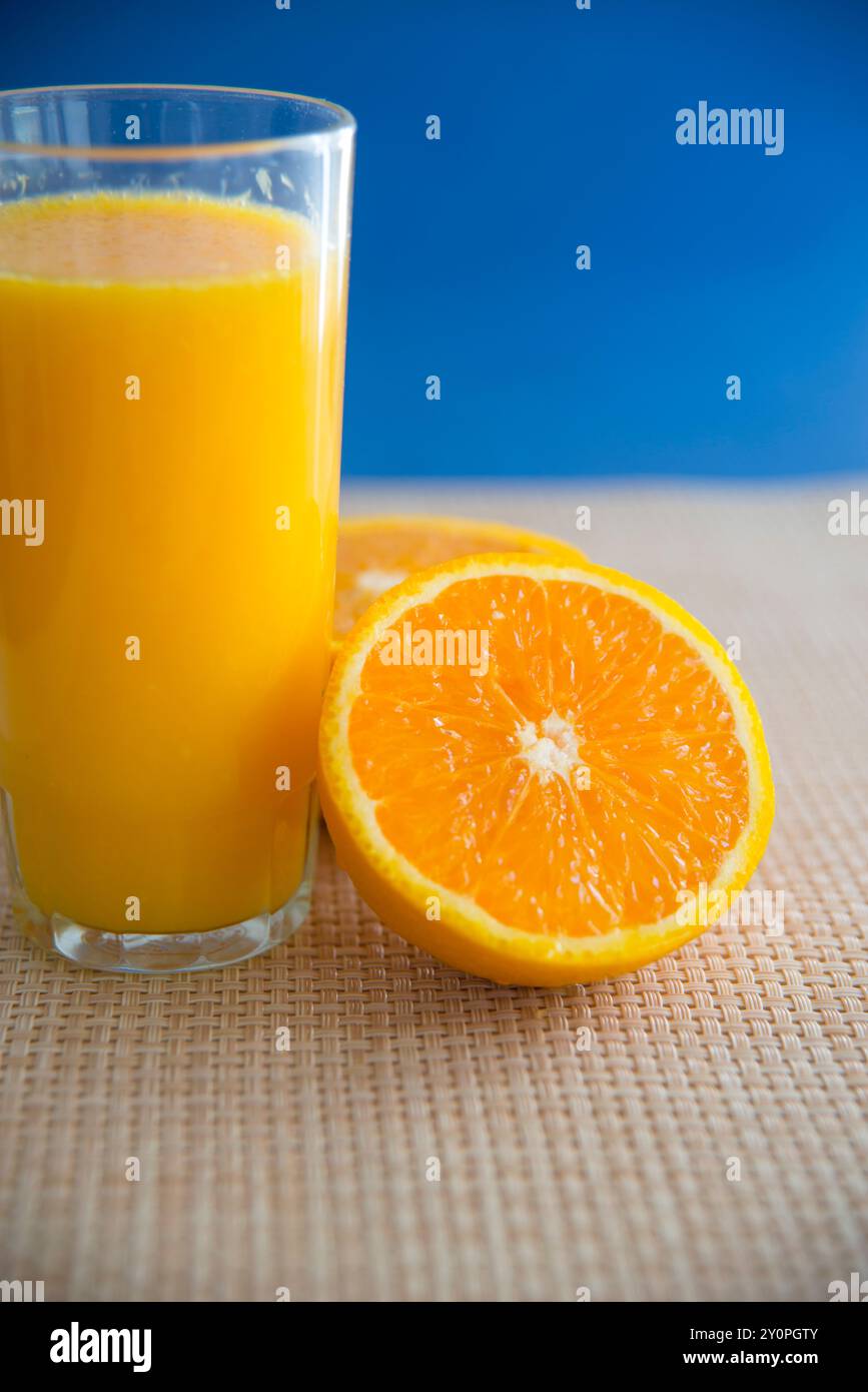 Bicchiere di succo d'arancia con un taglio d'arancia in due metà. Vista ravvicinata. Foto Stock