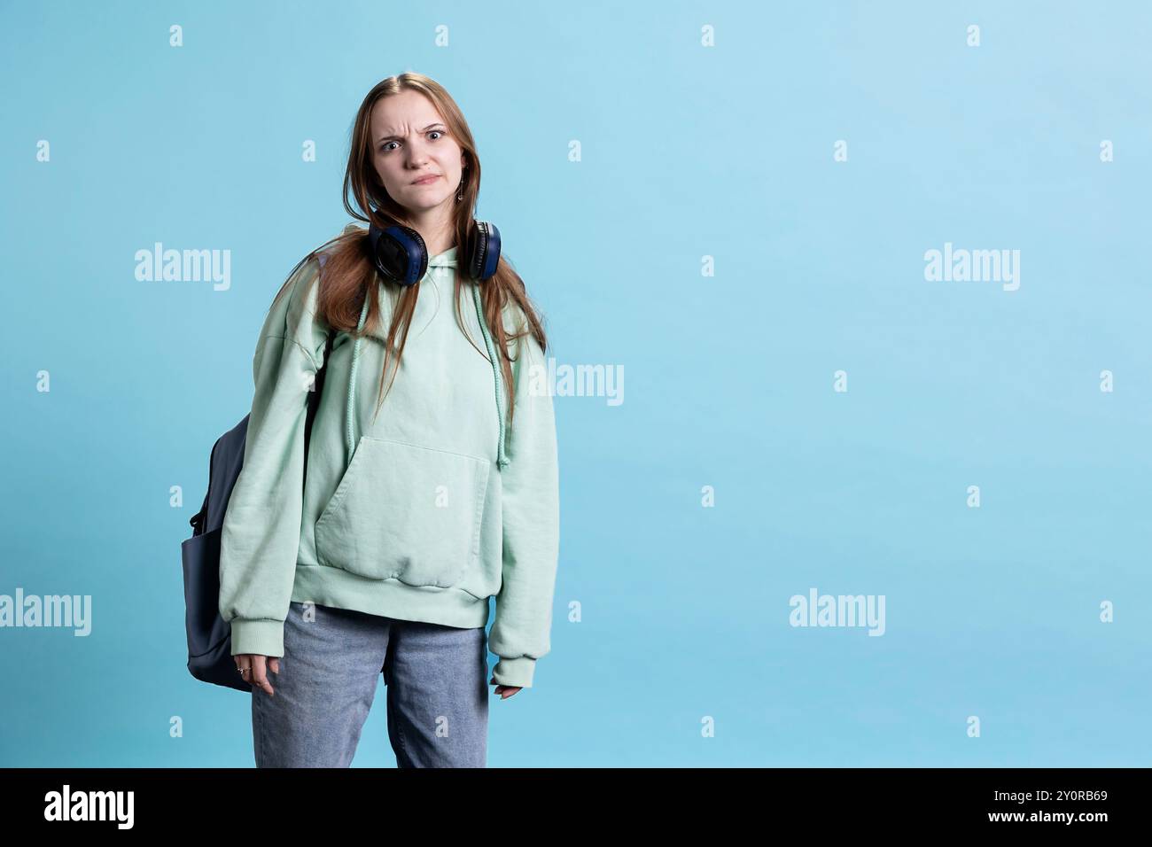 Una giovane attrice che si diverte, cambia le emozioni, prova diverse espressioni facciali, pratica per le lezioni di teatro, isolata sullo sfondo dello studio. Adolescente che fa facce sciocche, Foto Stock