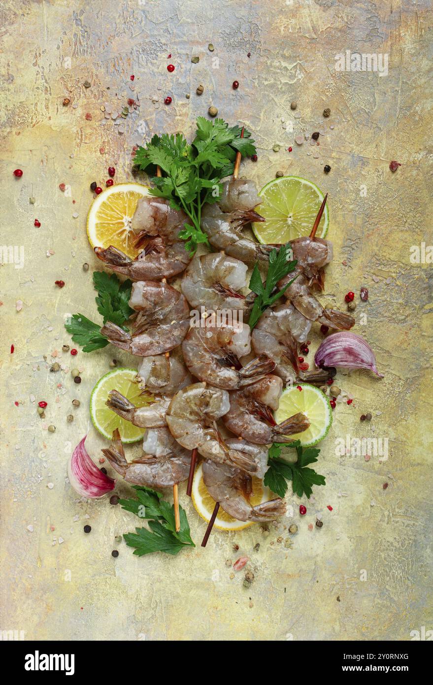 Gamberi crudi su spiedini, kebab di gamberi, fette di lime e limone, spezie ed erbe aromatiche, vista dall'alto, senza persone Foto Stock