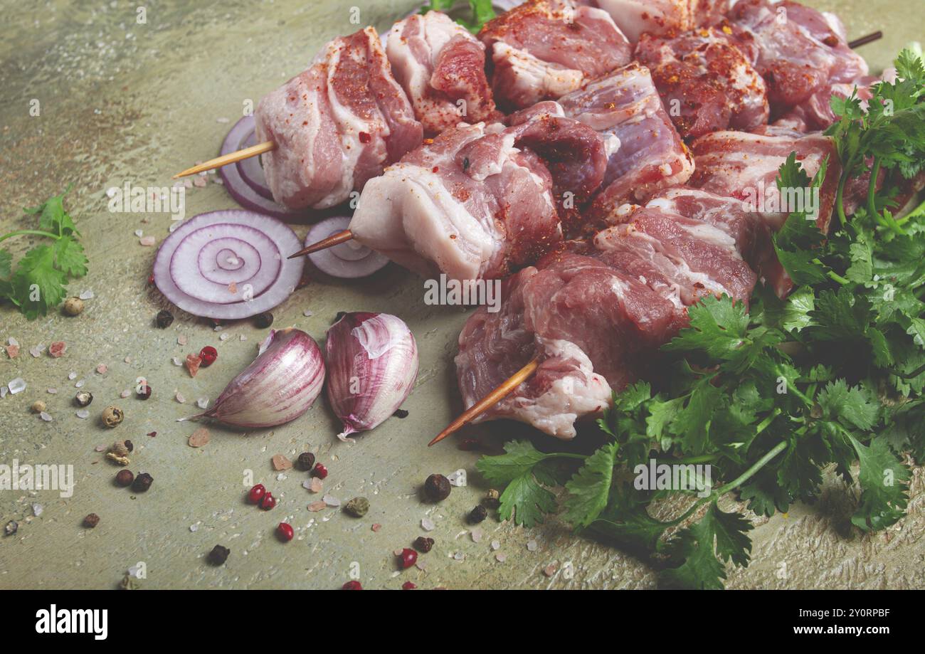 Carne di maiale cruda, spiedini di legno, kebab sottaceto, con spezie ed erbe aromatiche, sul tavolo, vista dall'alto, niente persone Foto Stock