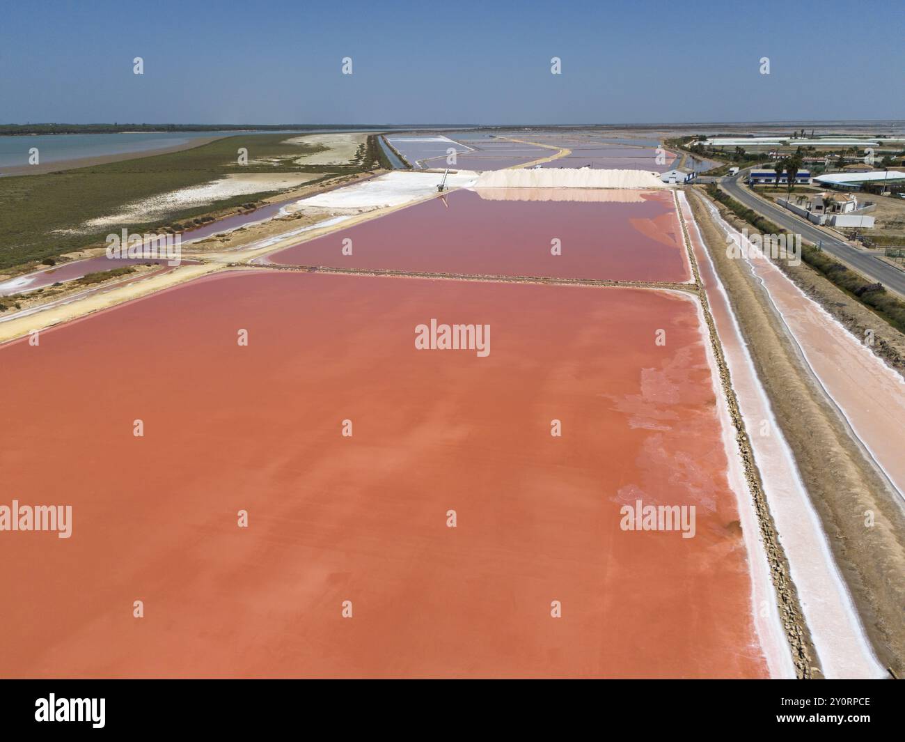 Veduta aerea del bacino di sale rosa con le infrastrutture circostanti e cielo limpido e piatto, Salinas de Bonanza, Sanlucar de Barrameda, Sanlucar de Barrameda, Foto Stock