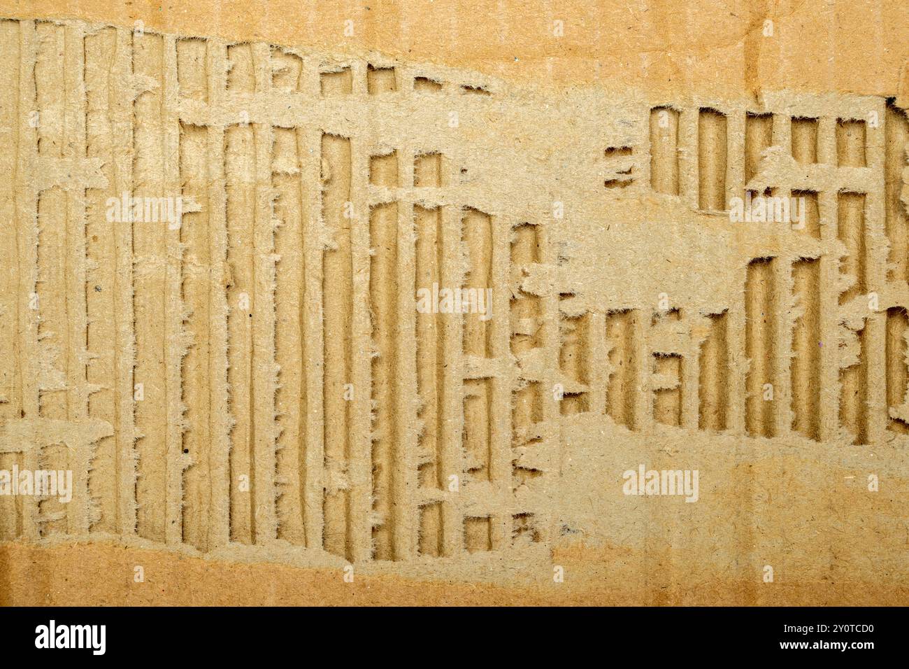 Una scatola di cartone con un foro. Il foro si trova al centro della scatola ed è circondato da alcuni pezzi di cartone. La casella sembra essere stata o. Foto Stock