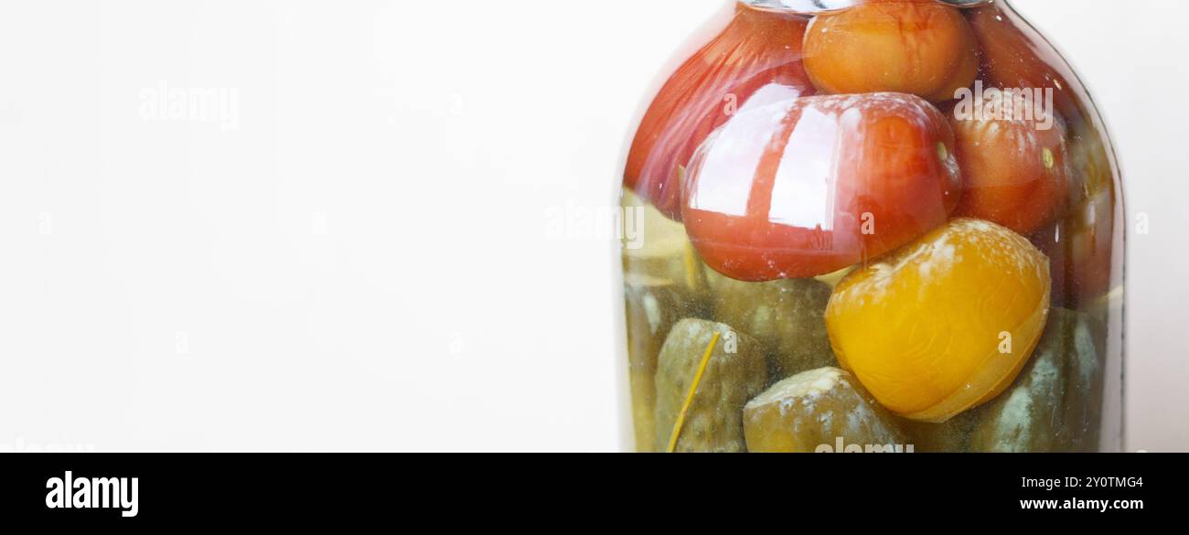 barattolo di verdure rovinato. Vaso di vetro con tomati sottaceto e cetrioli fatti in casa Foto Stock