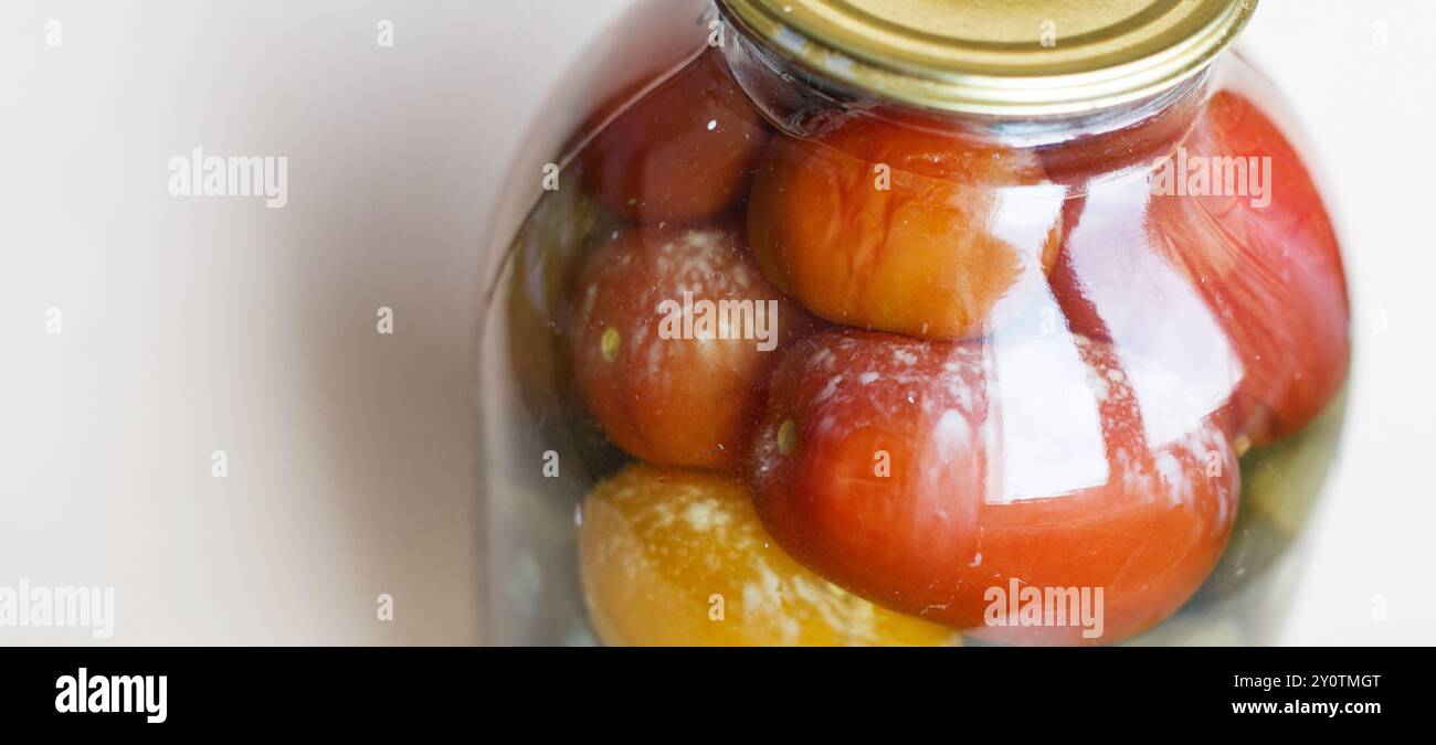 lattina viziata di aggraffatura vegetale. Vaso in vetro con pomodori e cetrioli fatti in casa sottaceto con funghi bianchi e muffa Foto Stock
