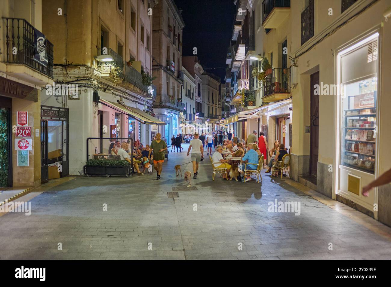 Sitges, Barcellona - 04 settembre 2024: Strada illuminata dal fascino mediterraneo, ideale per una passeggiata notturna. Foto Stock