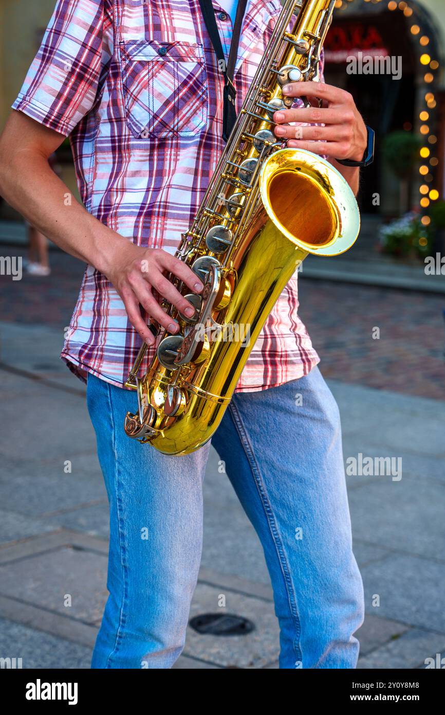 Talentuoso sassofono che intrattiene i passanti con Soulful Melodies in un affollato angolo di City Street Foto Stock