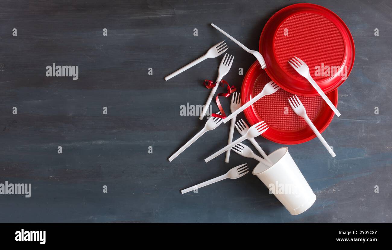 Forcelle in plastica monouso bianche e piastre pastiche rosse. Posizione piana con spazio di copia libero. Non utilizzare plastica monouso per il cibo da asporto. po. Ambientale Foto Stock