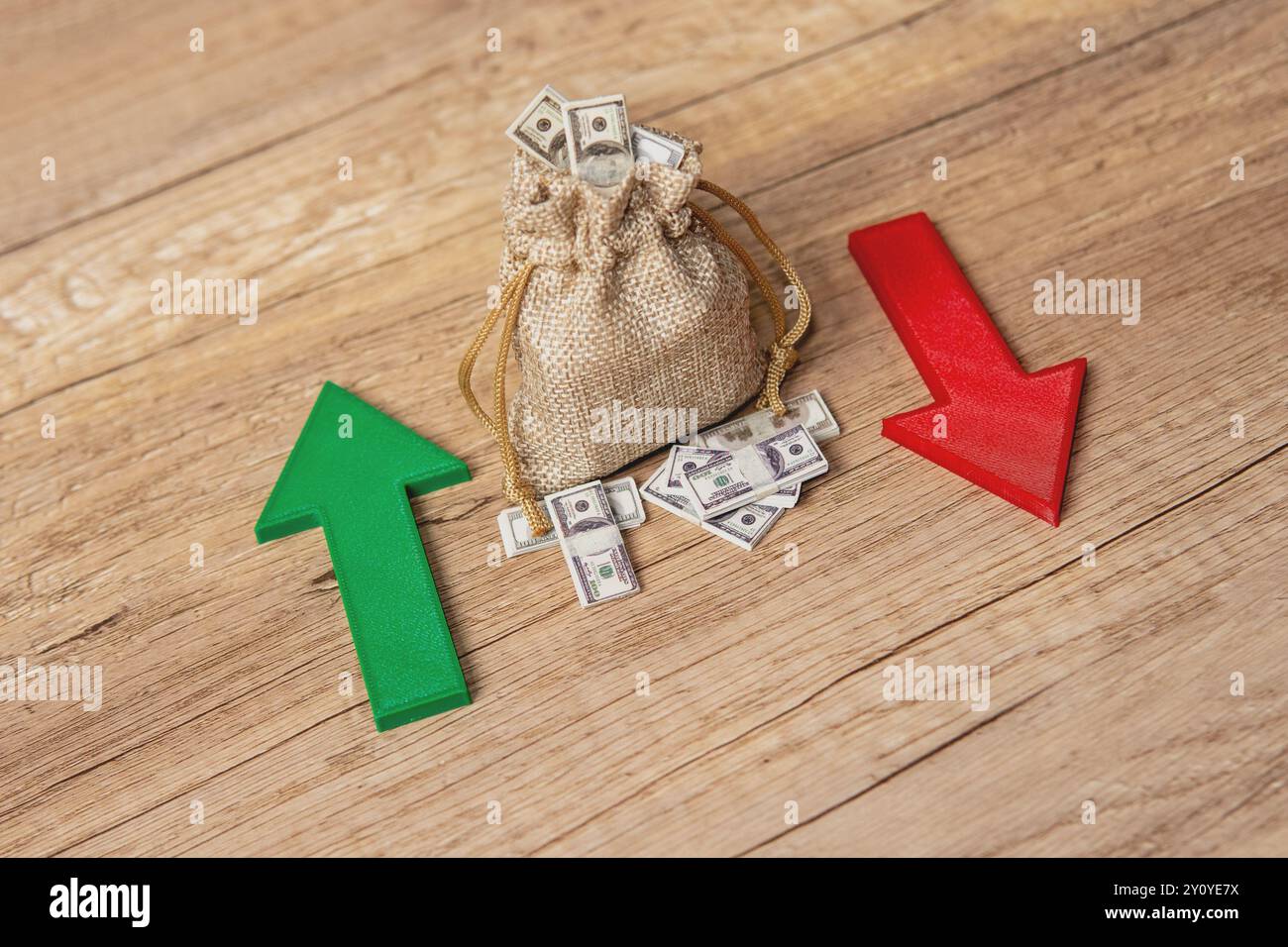 Un sacco pieno di banconote da un dollaro tra una freccia verde verso l'alto e una freccia rossa verso il basso. Fluttuazioni degli investimenti, volatilità del mercato, profitti e. Foto Stock