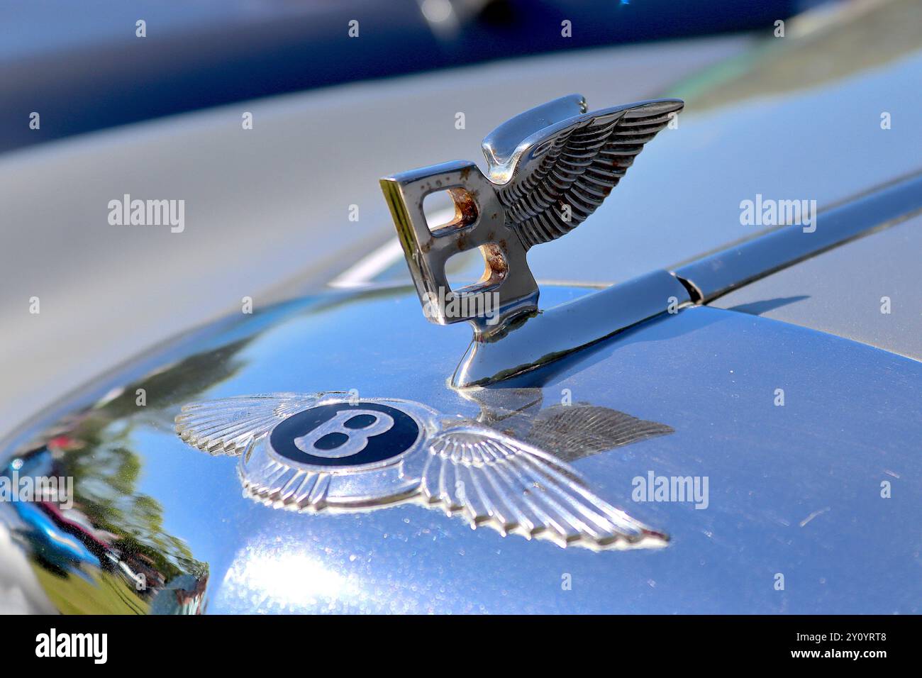 La famosa mascotte volante "B" sopra il leggendario distintivo alato Bentley Radiator progettato dall'artista e scultore F. Gordon Crosby. Foto Stock