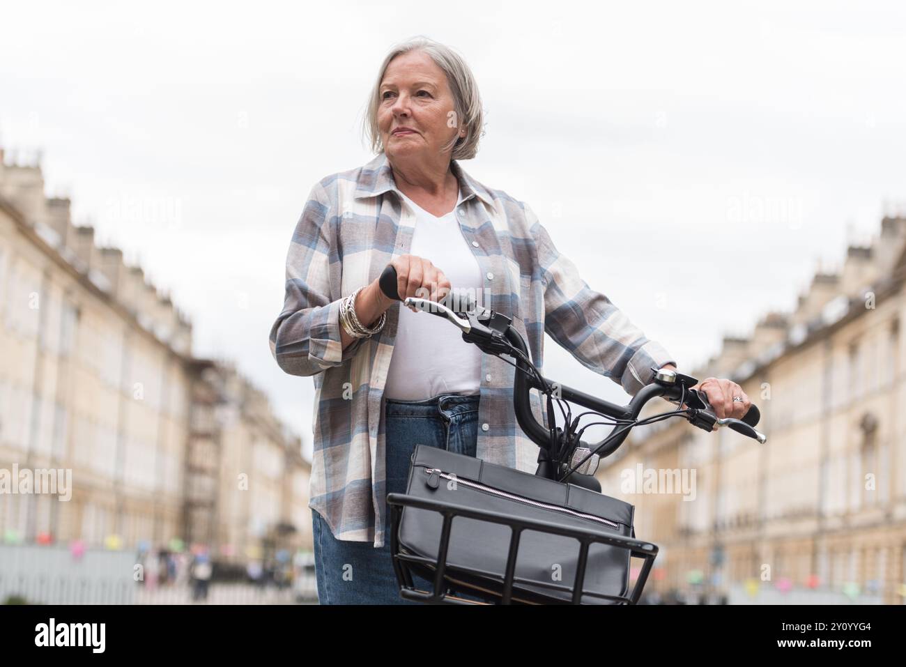 Donna anziana su una bici elettrica in pausa Foto Stock