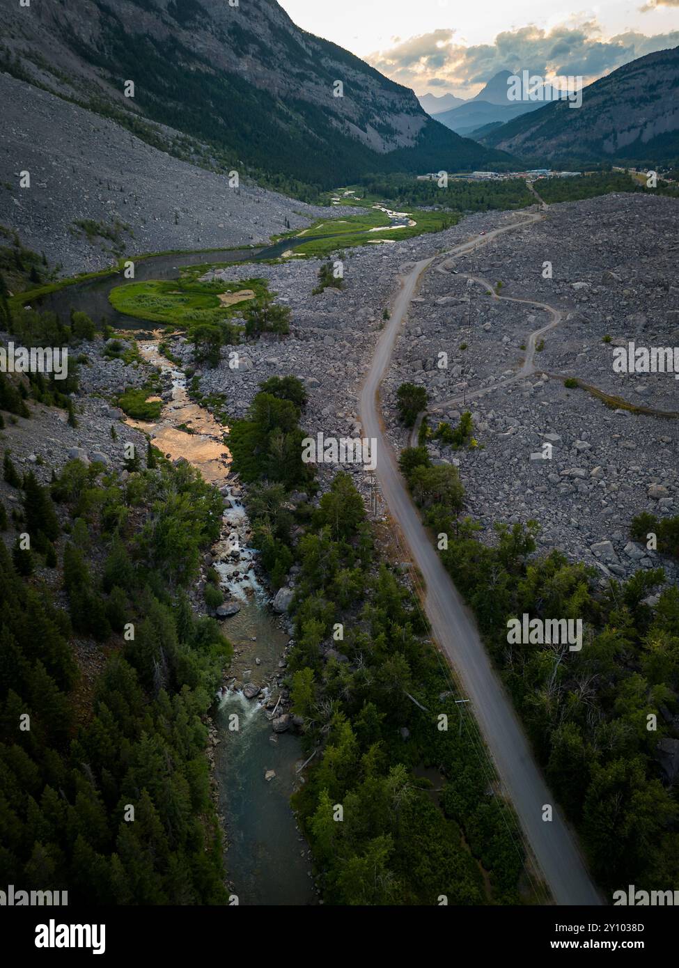 La strada di ghiaia è parallela a un fiume che si affaccia sul sito storico di Frank Slide e al Crowsnest Pass in Alberta Canada Foto Stock