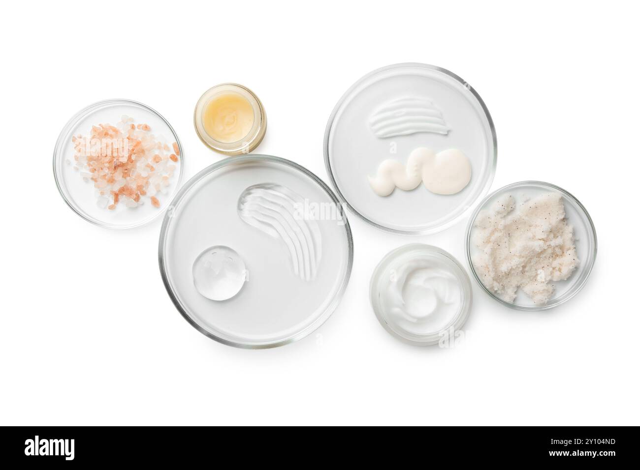 Capsule di Petri con diversi prodotti cosmetici isolati su bianco, vista dall'alto Foto Stock