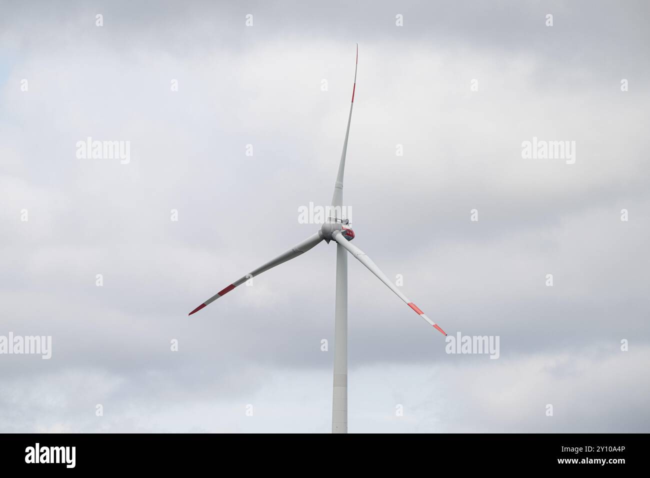 , Deutschland, Rheinland-Pfalz, Hatzenbühl, 04.09.2024, Eine Großaufnahme eines Windrads mit rot markierten Rotorblättern, das sich ruhig vor einem b Foto Stock