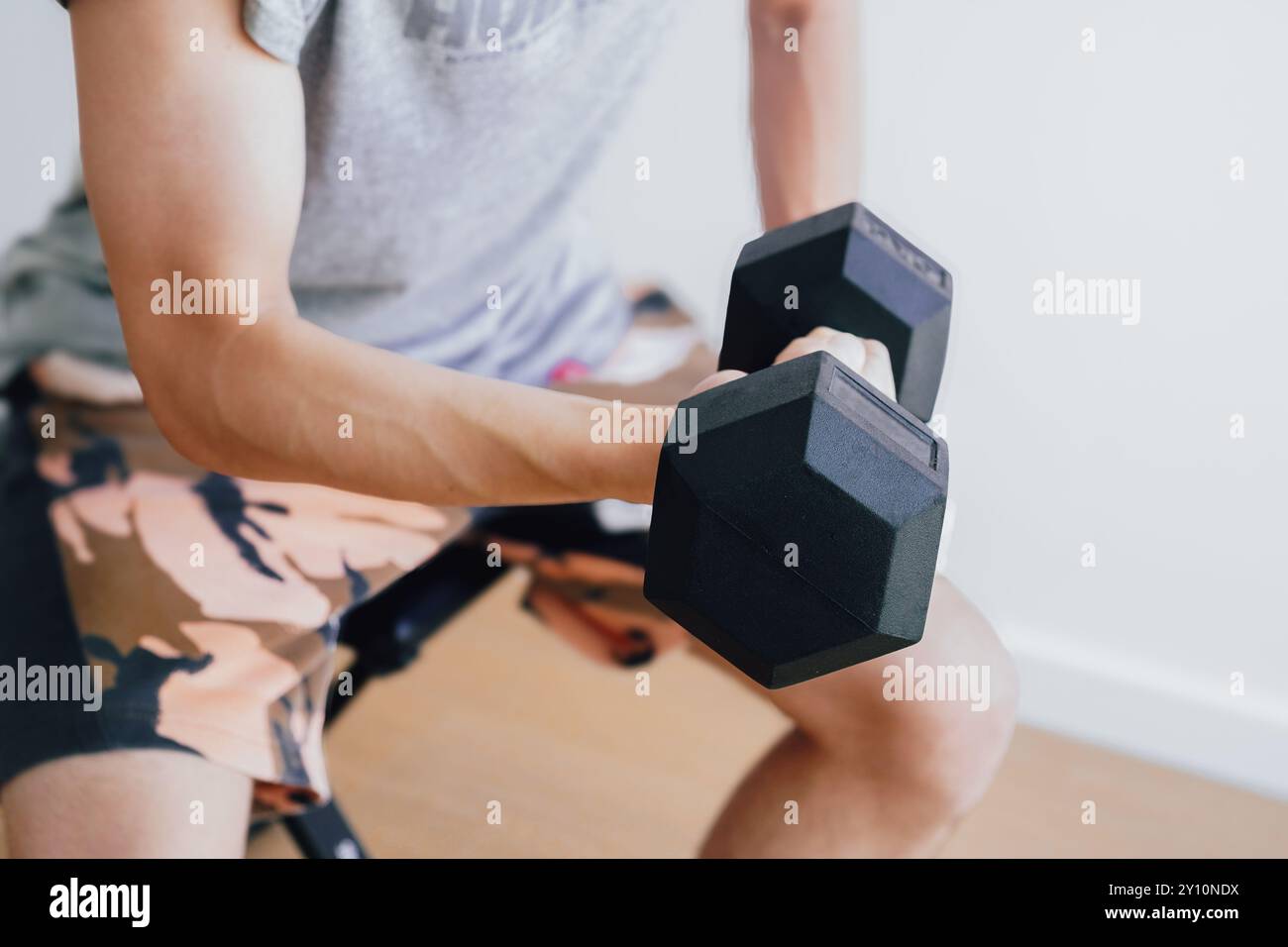 Uomo che si allena con i manubri a casa Foto Stock