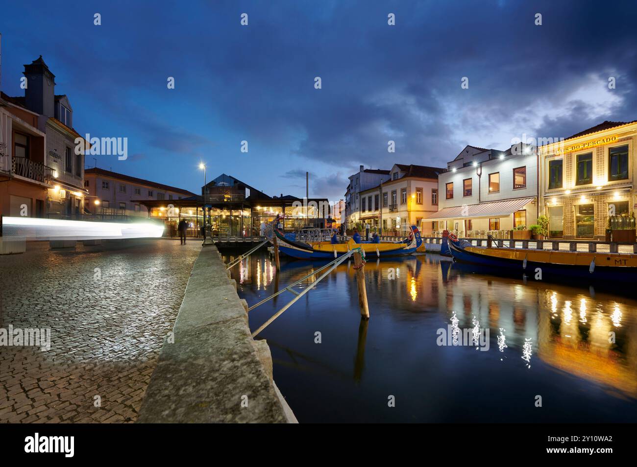 Vista della città di Aveiro, chiamata la Venezia del Portogallo, vista notturna del porto con il mercato, luci riflesse nell'acqua Foto Stock