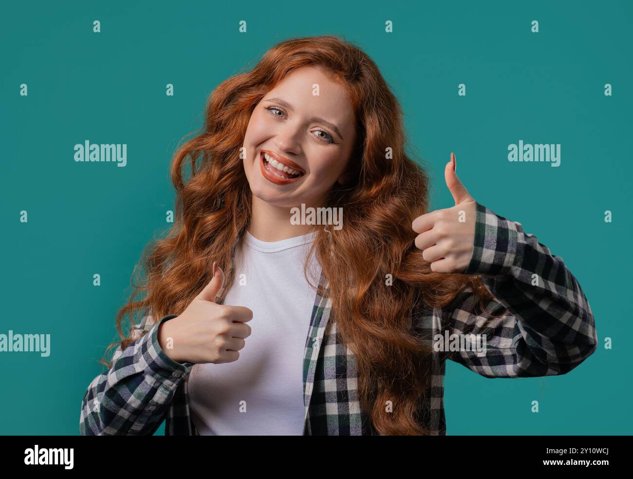 Donna felice con il segno della mano tipo, alza il gesto con il pollice. Felice signora, scelta perfetta, ottimo rapporto qualità/prezzo, sfondo blu. Un modello femminile positivo sorride Foto Stock
