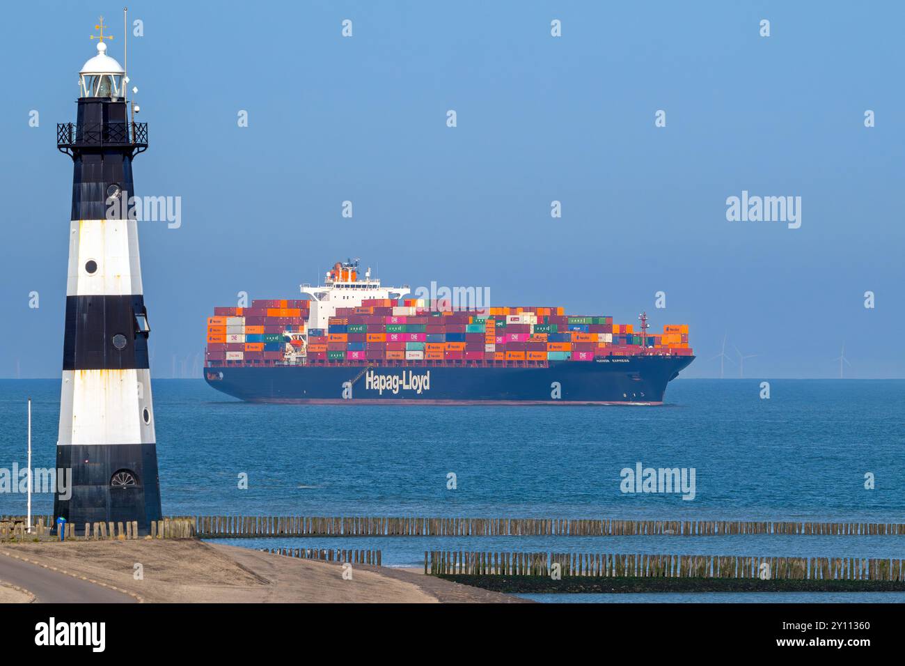 Nave portacontainer/container Hudson Express della compagnia di navigazione Hapag-Lloyd AG che naviga sulla Schelda occidentale oltre il faro di Breskens Foto Stock