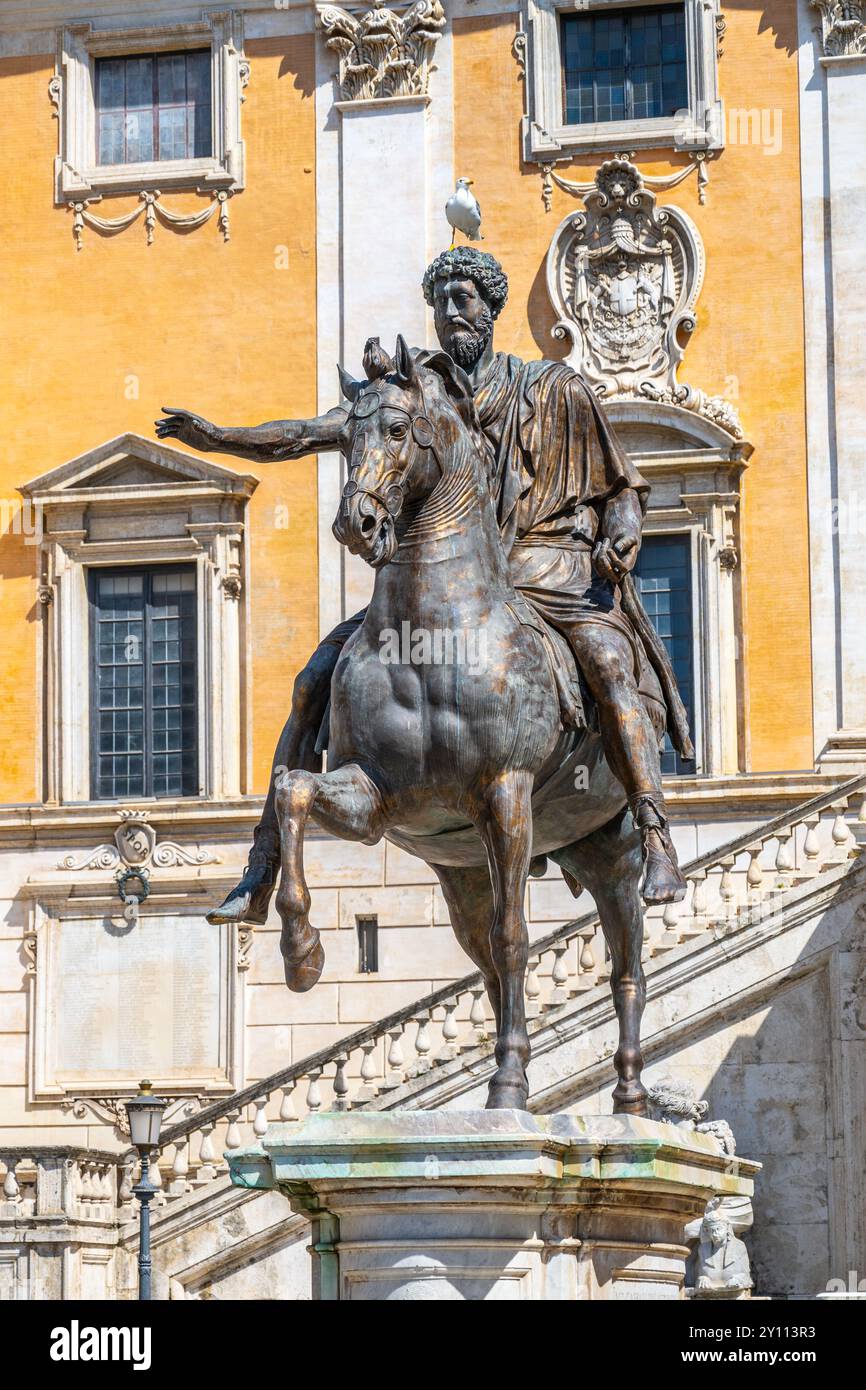 L'imponente statua equestre di Marco Aurelio si erge maestosamente sul Campidoglio, mostrando l'antica arte e storia romana in un vivace ambiente urbano. Foto Stock