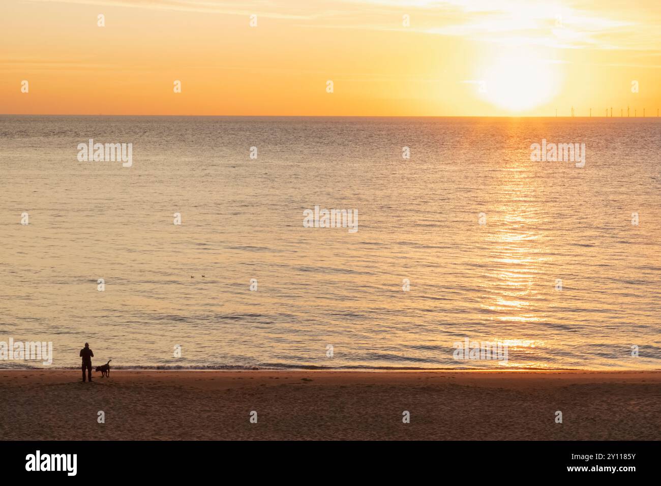 Inghilterra, Kent, Kingsgate Bay, Man and Dog on Beach at Sunrise Foto Stock
