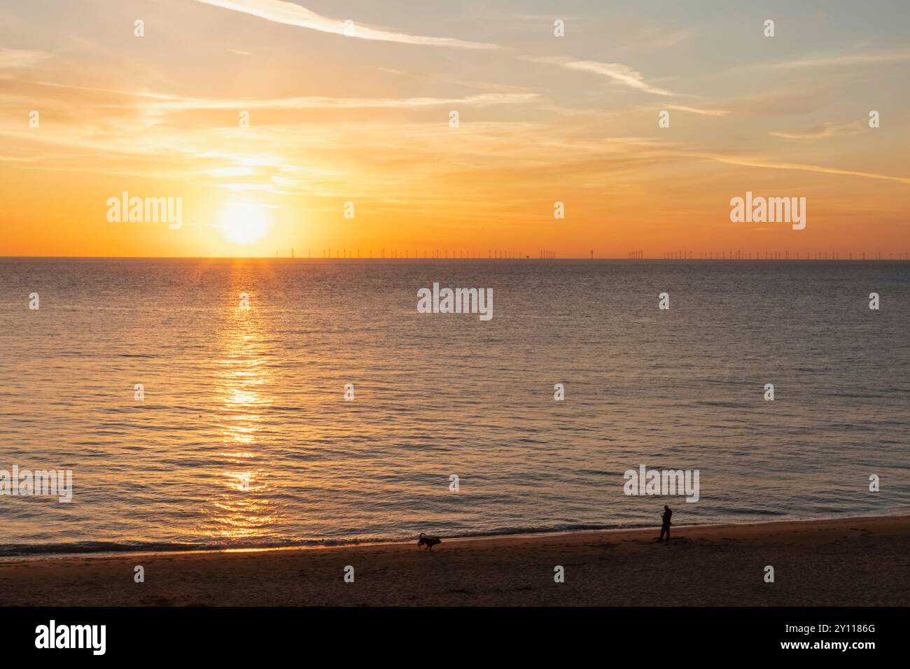 Inghilterra, Kent, Kingsgate Bay, Man and Dog on Beach at Sunrise Foto Stock