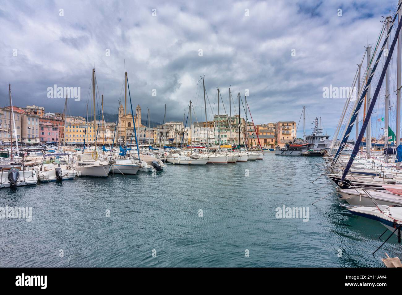 Barche a vela e a motore ormeggiate nel porto turistico di Bastia, sullo sfondo la chiesa e gli edifici che si affacciano sul porto. Bastia, Haute-Corse, alta Corsica, Francia Foto Stock