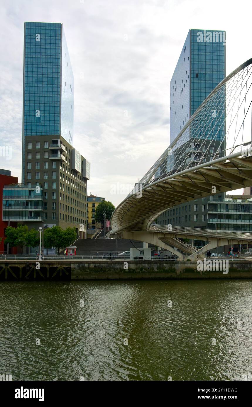Le torri gemelle del complesso della porta di Isozaki e il ponte pedonale Zubizuri ad arco legato sul fiume Nerbiol Bilbao Paesi Baschi Euskadi Spagna Foto Stock