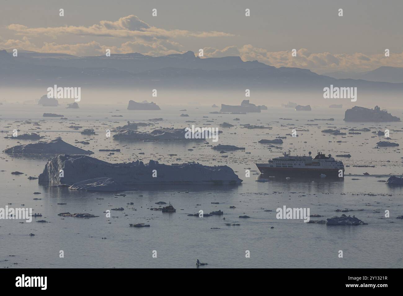 La nave Hurtigruten naviga attraverso iceberg e banchi di ghiaccio, estate, sole di mezzanotte, ghiacciaio e fiordo di ghiaccio Jakobshavn, Ilulissat Kangerlua, Disko Bay, West Gr Foto Stock