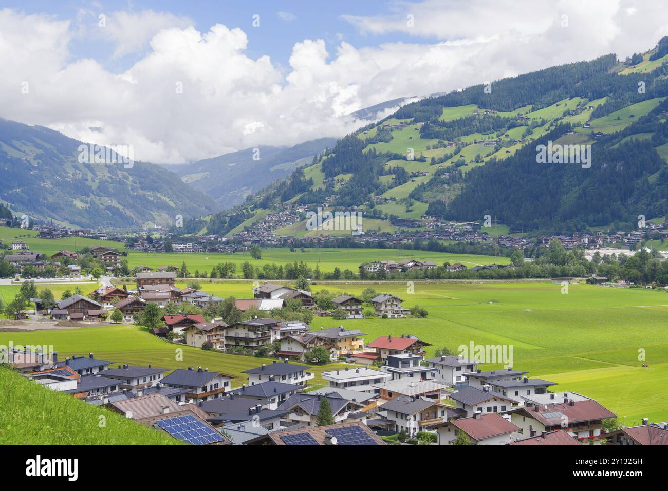 Villaggio alpino con molte case e verdi colline, circondato da maestose montagne, Mayrhofen, Zillertal, Austria, Europa Foto Stock