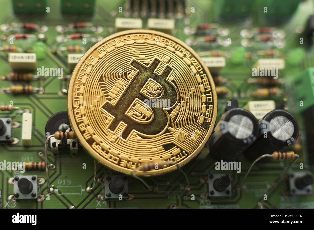 Moneta d'oro Bitcoin su microchip per circuiti stampati. Criptovaluta elettronica Foto Stock