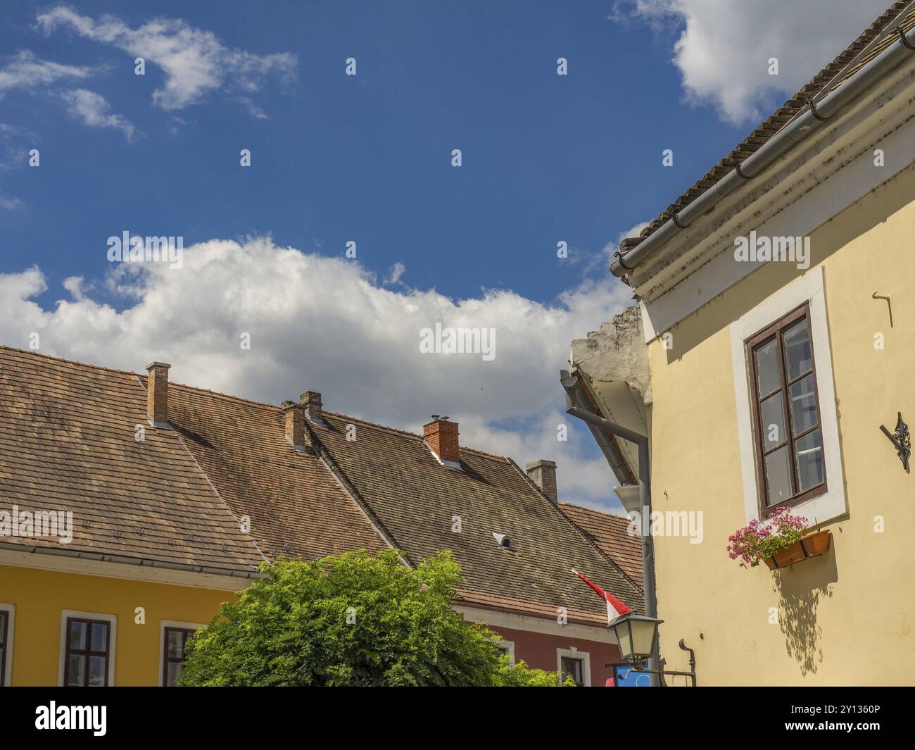 Diverse case con tetti rossi sotto un cielo azzurro limpido con nuvole, esztergom, danubio, ungheria Foto Stock