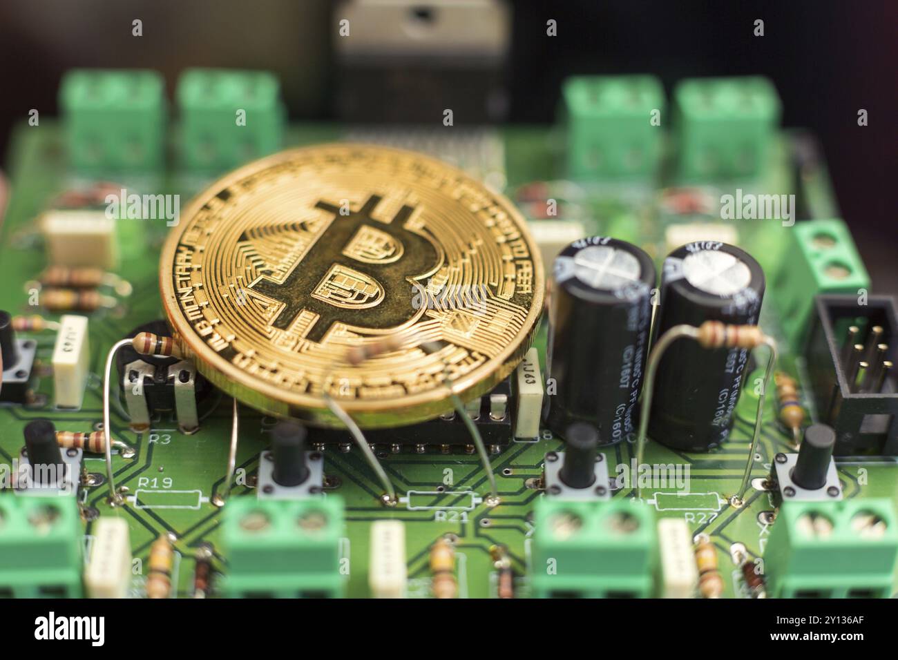 Moneta d'oro Bitcoin su microchip per circuiti stampati. Criptovaluta elettronica Foto Stock